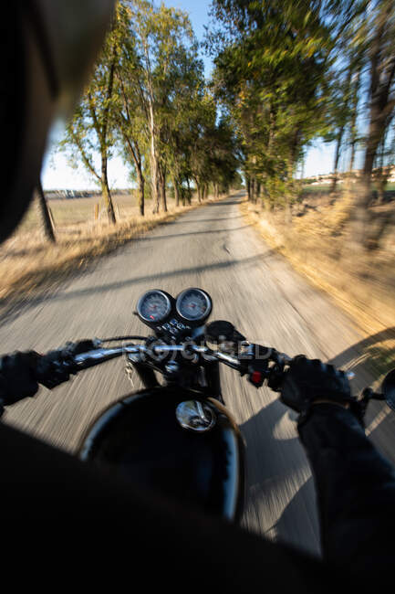 Back view of faceless fast racer riding motorbike through forest in rural location — Stock Photo