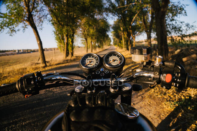 Visão traseira do piloto rápido sem rosto andando de moto através da floresta na localização rural — Fotografia de Stock