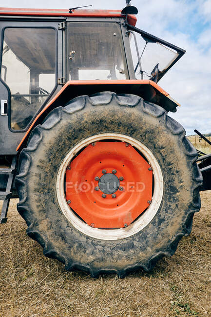 Tractor moderno colocado en el campo agrícola en la zona montañosa en verano - foto de stock