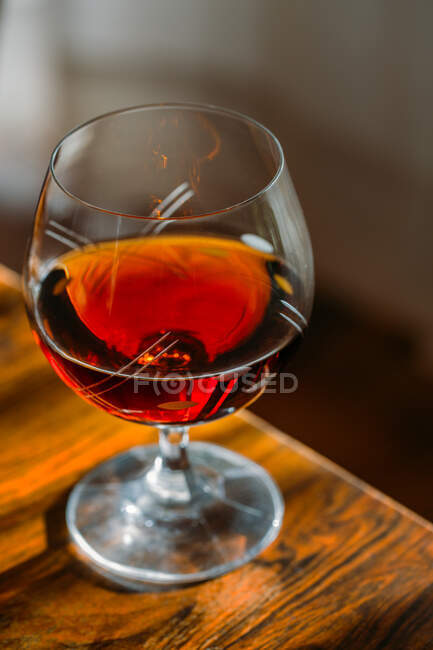 Vidro de conhaque à moda antiga em mesa de madeira com luz natural — Fotografia de Stock