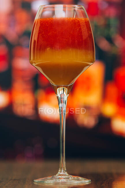 Nahaufnahme eines roten und orangefarbenen Cocktails vor verschwommenem Hintergrund — Stockfoto