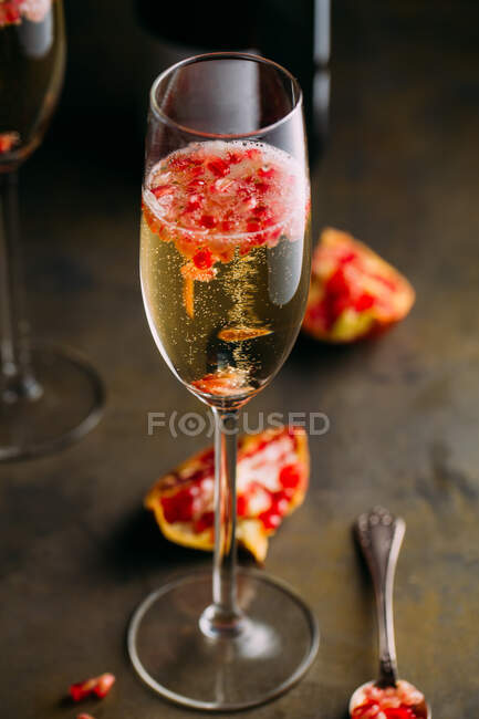 Natura morta composizione di cocktail di champagne con melograno su una superficie rustica — Foto stock