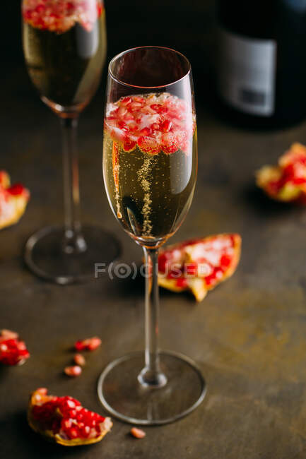 Stillleben-Komposition aus Champagner-Cocktail mit Granatapfel auf rustikaler Oberfläche — Stockfoto