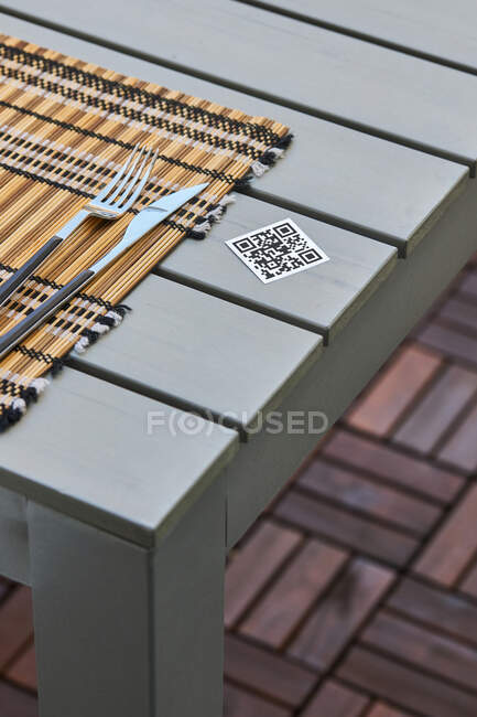 High angle of QR code of menu of Asian restaurant placed on table with napkin and knife and fork — Stock Photo