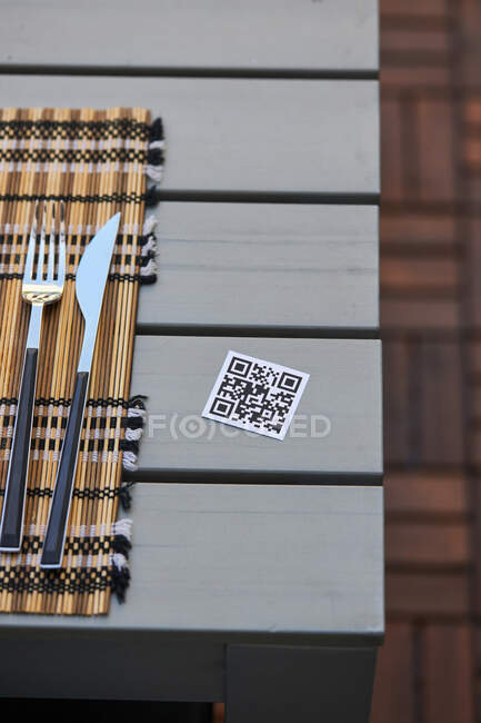 Высокий угол QR-кода меню азиатского ресторана на столе с салфеткой и ножом и вилкой — стоковое фото