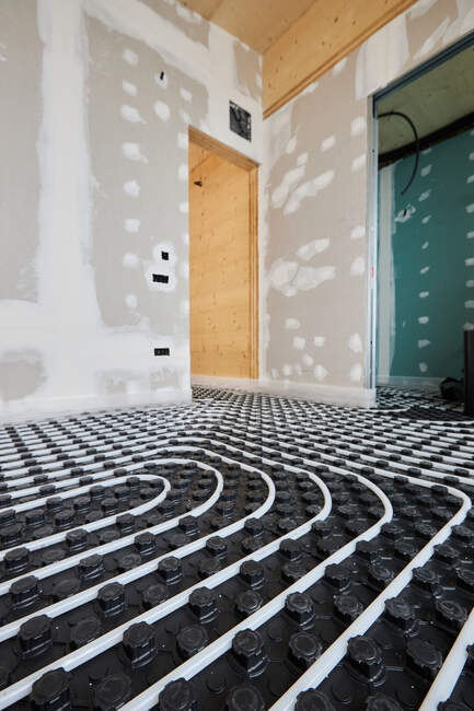Hoher Winkel der Heizungsanlagen mit Rohren, die auf dem Fußboden in einem modernen Holzhaus installiert sind — Stockfoto