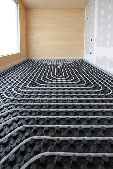 High angle of radiant heating systems with pipes installed on floor in contemporary wooden cottage — Stock Photo