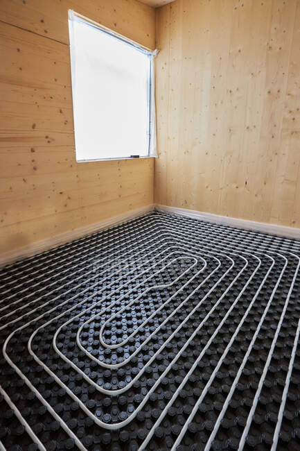 Alto ángulo de sistemas de calefacción radiante con tuberías instaladas en el suelo en la casa de madera contemporánea - foto de stock