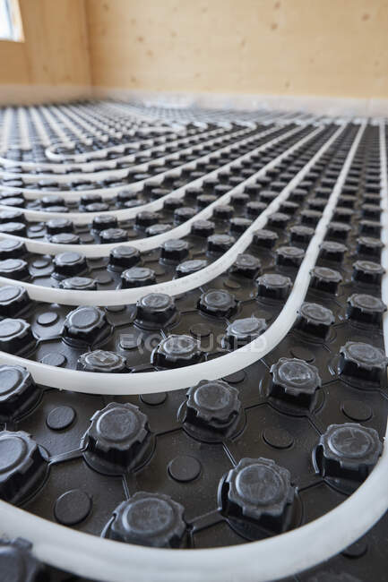 Systèmes de chauffage radiant à angle élevé avec tuyaux installés sur le sol dans un chalet contemporain en bois — Photo de stock