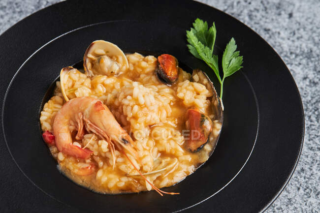 From above of appetizing rice with assorted seafood served on plate on table in restaurant — Stock Photo
