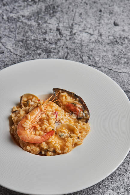 Dall'alto di riso appetitoso con frutti di mare assortiti serviti sul piatto sul tavolo nel ristorante — Foto stock