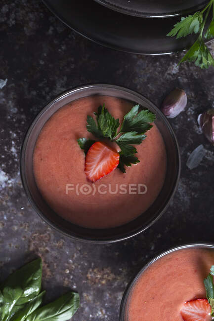Top view of bowls with fresh strawberry gazpacho cold soup placed on dark table — Stock Photo