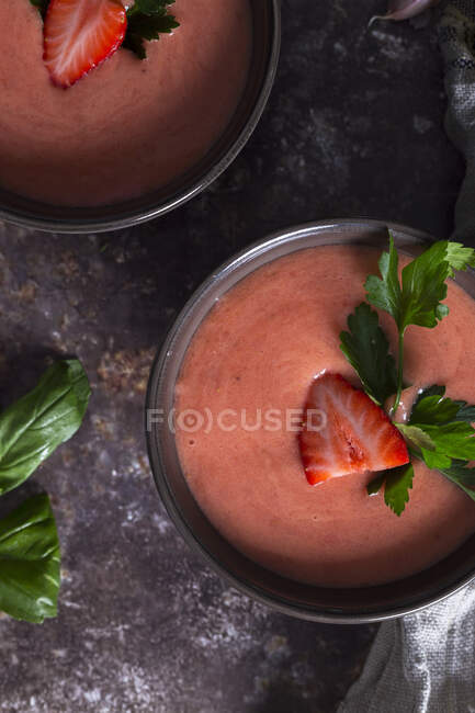 Vue du dessus des bols à la fraise fraîche gaspacho soupe froide placée sur la table noire — Photo de stock