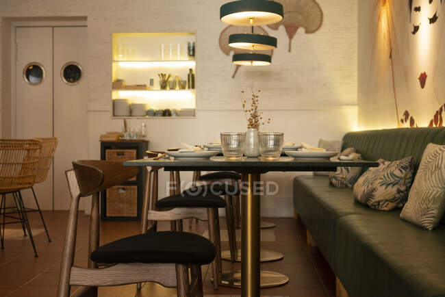 Interior acolhedor do restaurante asiático com sofá confortável e mesas de vidro servidas com utensílios de mesa — Fotografia de Stock