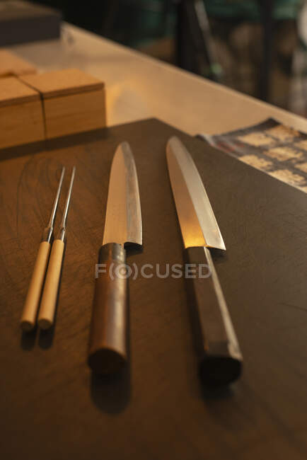 Sharp knives placed on wooden table in Asian restaurant — Stock Photo