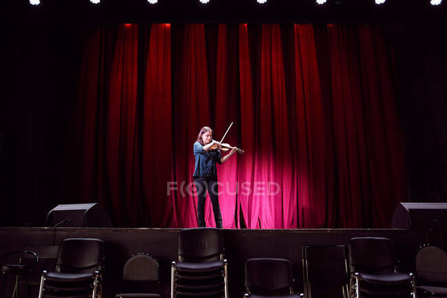 Ganzkörper-professionelle Geigerin tritt während der Probe live auf der Bühne im leeren Konzertsaal auf — Stockfoto