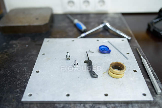Alto ângulo de instrumentos variados colocados em placa de metal em oficina de reparo profissional — Fotografia de Stock
