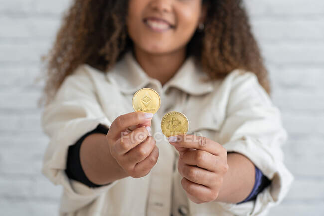 Unerkennbares schwarzes Mädchen hält Kryptowährung in Händen — Stockfoto