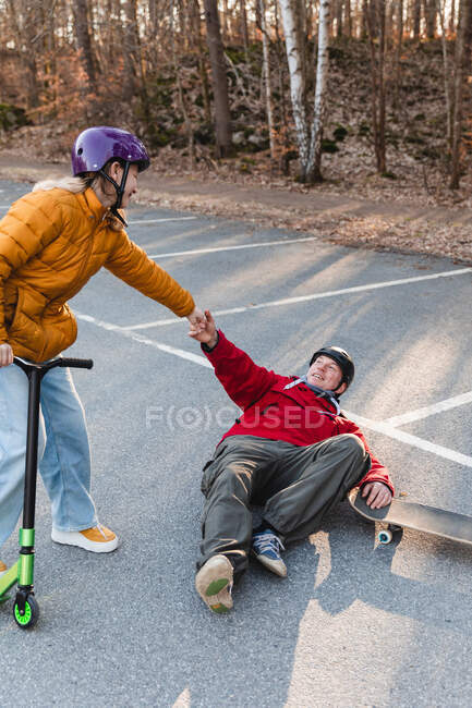 From above daughter helping her father to get up off the ground — Stock Photo
