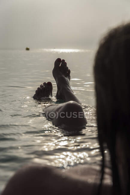 Ernten Sie barfüßige Beine eines nicht wiederzuerkennenden Weibchens, das im Meerwasser liegt und den sonnigen Morgen im Urlaub an der Playa de Muro genießt — Stockfoto