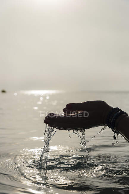 Crop faceless female with handful of water in wet hands in sea in morning in Alcudia — Stock Photo