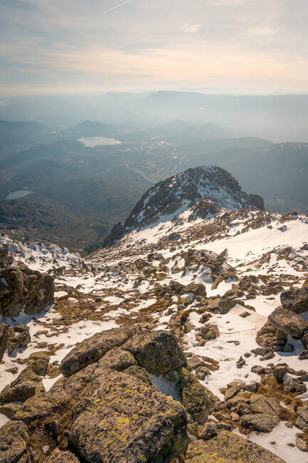 Paesaggio pittoresco di vetta di montagne coperte di neve situato in Sierra de Guadarrama in Spagna sotto cielo nuvoloso alla luce del giorno — Foto stock