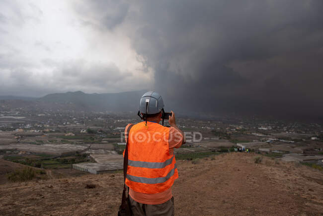 Vue arrière d'un homme anonyme observant le volcan en éruption de Cumbre Vieja dans les îles Canaries de La Palma 2021 — Photo de stock