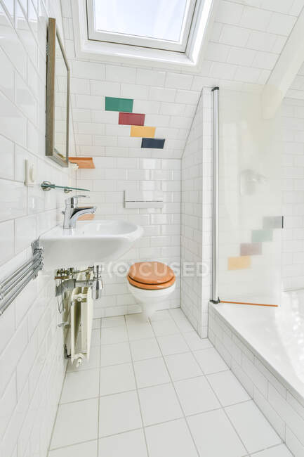 Interno della casa bagno con specchio appeso sopra lavabo collocato vicino alla porta d'ingresso e cabina doccia in vetro in appartamento moderno — Foto stock