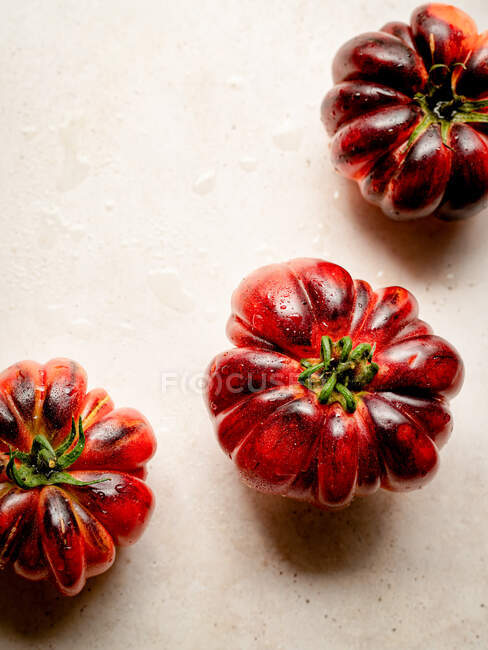 Gros plan de plusieurs tomates rouges sur une table blanche — Photo de stock