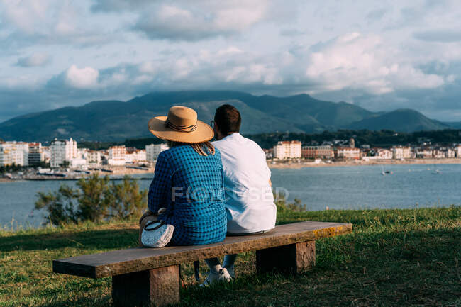Blick zurück auf ein anonymes Touristenpaar, das Meer und Berg unter wolkenlosem blauen Himmel in Saint Jean de Luz betrachtet — Stockfoto