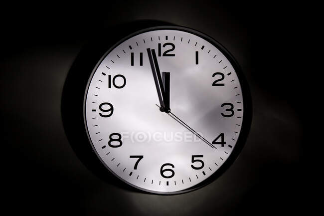 Runde minimalistische Uhr mit Zahlen und Pfeilen auf schwarzem Hintergrund — Stockfoto