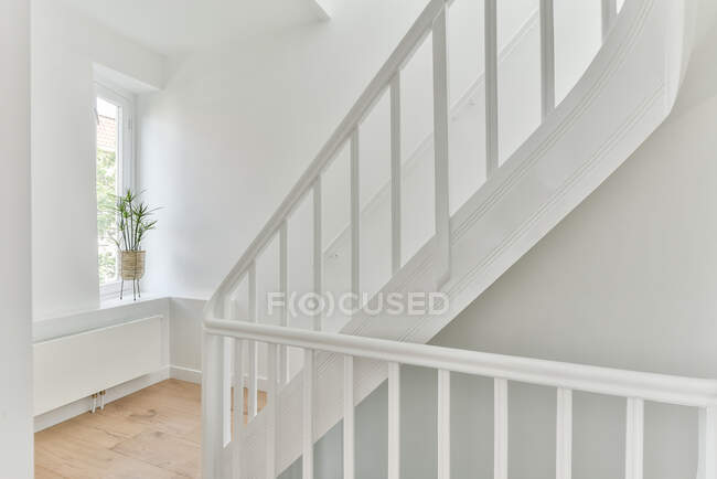 Wooden white railing of stairway in big private house with light painted walls — Stock Photo