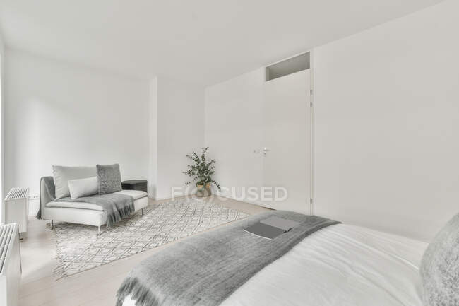 Інтер'єр просторої світлої спальні зі зручним ліжком в сучасній квартирі вдень — стокове фото
