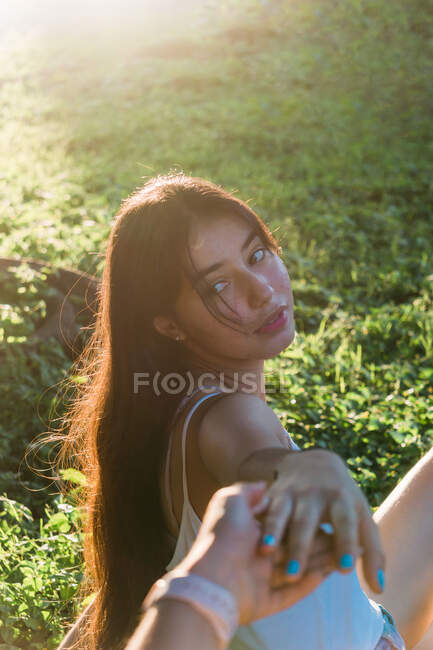 Side view of female adolescent with long hair holding crop best friend by hand in back lit — Stock Photo