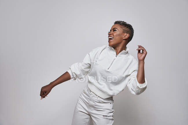 Energetic ethnic woman in trendy clothes dancing hip hop with open mouth and eyes closed — Stock Photo