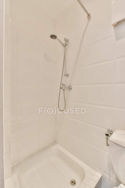 Interior da casa de banho vazia com chuveiro e paredes de azulejos leves no apartamento — Fotografia de Stock