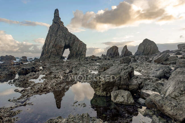 Spettacolare scenario con onde di mare schiumose lavare formazioni rocciose grezze di varie forme in spiaggia campiecho nelle Asturie Spagna — Foto stock
