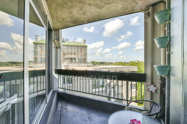 Стол и стул расположены на маленьком уютном балконе квартиры в жилом доме — стоковое фото