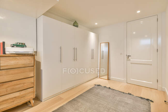 Interior of modern bedroom with big wardrobe and chest of drawers in new apartment — Stock Photo