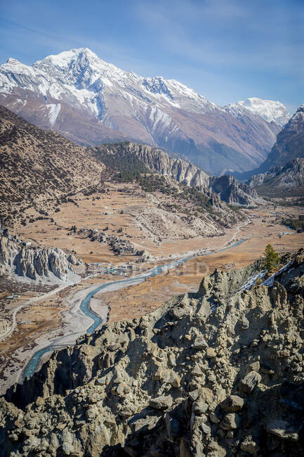 Paysage pittoresque de la rivière sinueuse qui coule entre de hautes montagnes escarpées avec des sommets enneigés dans les hautes terres du Népal — Photo de stock