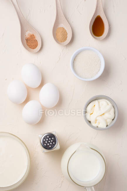 Вид зверху на компонування інгредієнтів для приготування смачного омлету, розміщеного на білому тлі в студії — стокове фото