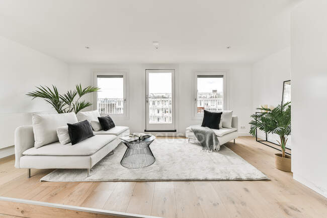 Interior design di camera spaziosa arredata con comodo divano vicino tavolo su moquette in appartamento moderno — Foto stock