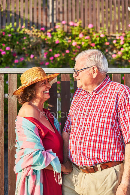 Щаслива стара пара насолоджується прогулянкою разом стоячи, дивлячись один на одного — стокове фото