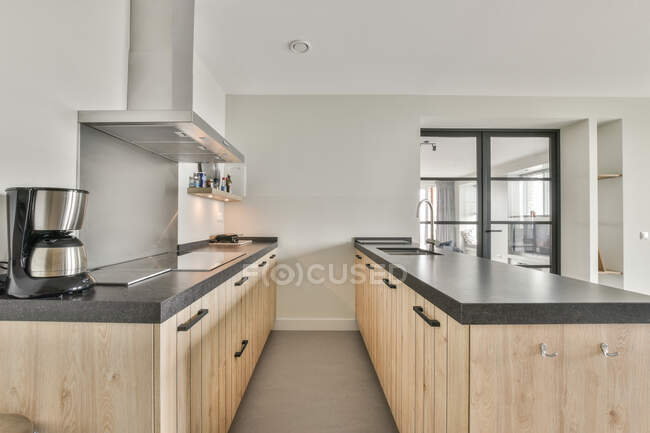 Інтер'єр кухонної зони з дерев'яними шафами в сучасній квартирі з мінімалістичним дизайном — стокове фото