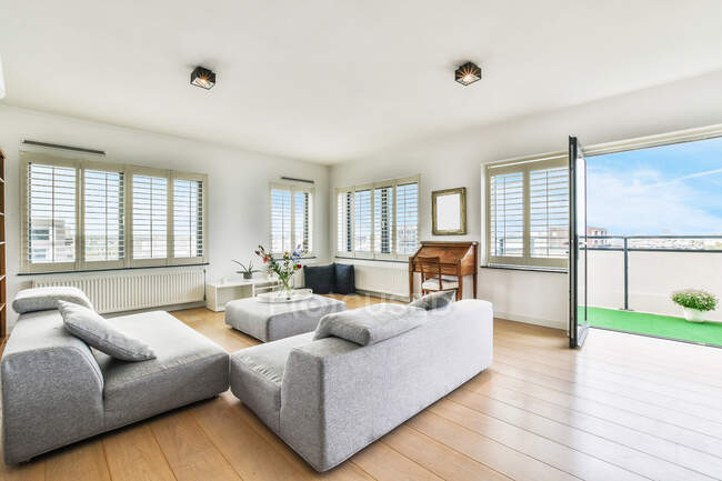 Сучасний інтер'єр кімнати з диванами і столом проти віконного будинку в денне світло — стокове фото