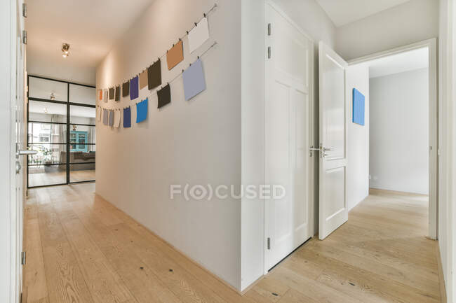 Flur der Wohnung mit einem Kranz leerer Papiere, die an einer weißen Wand mit Türen hängen — Stockfoto