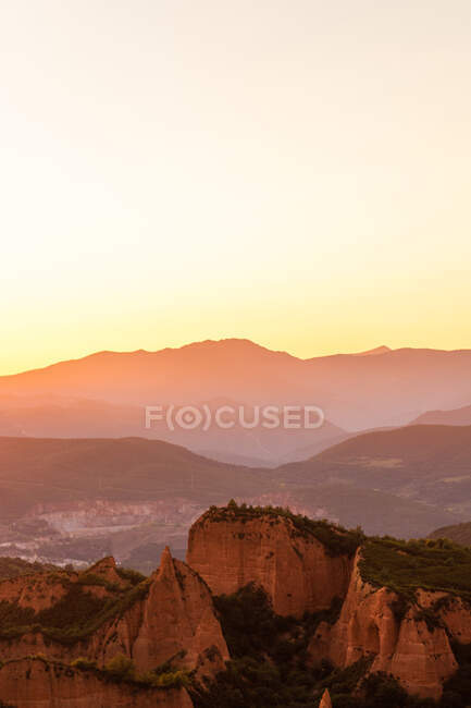 Vue pittoresque de magnifiques montures avec mousse et arbres sous un ciel clair au coucher du soleil — Photo de stock
