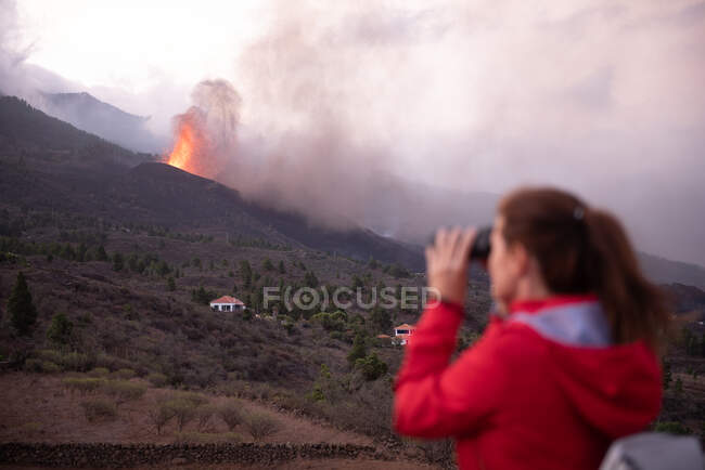 Mujer anónima observando el volcán en erupción de Cumbre Vieja en La Palma Islas Canarias 2021 - foto de stock