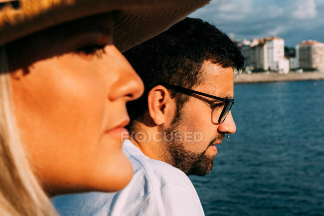 Vista lateral da cultura turista feminina contra namorado barbudo em óculos contemplando o oceano enquanto olha para longe em Saint Jean de Luz França — Fotografia de Stock