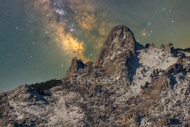 Magnificent landscape of rough rocky mountain peaks covered with snow under night starry sky with Milky Way — Stock Photo